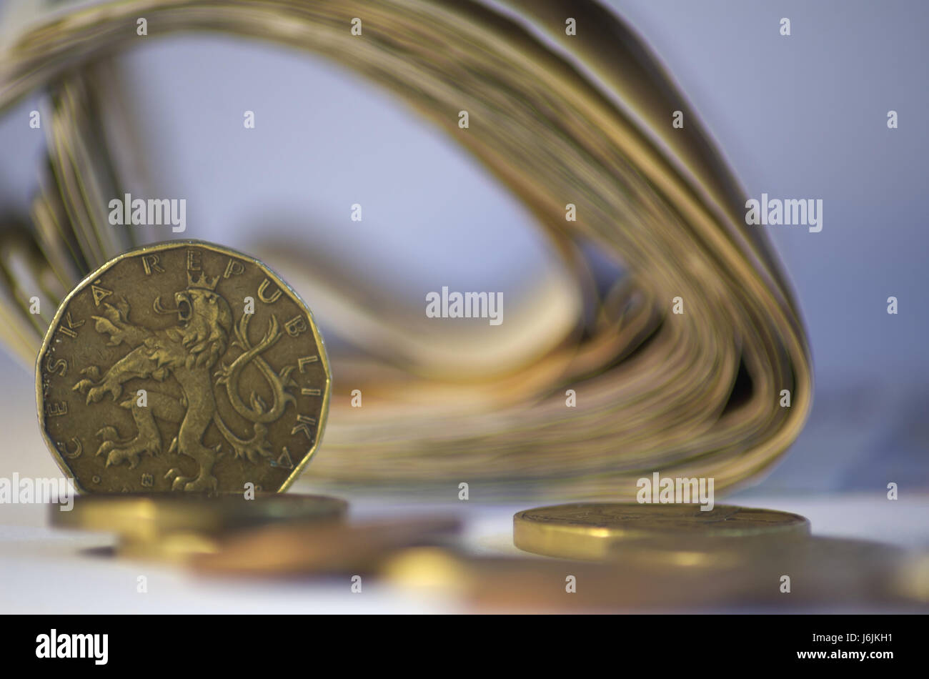 Tschechische Münzen und Blury Pack Geld im Hintergrund. Zwanzig tschechische Krone im Vordergrund mit Münzen und Blury Pack Geld im Hintergrund. Stockfoto