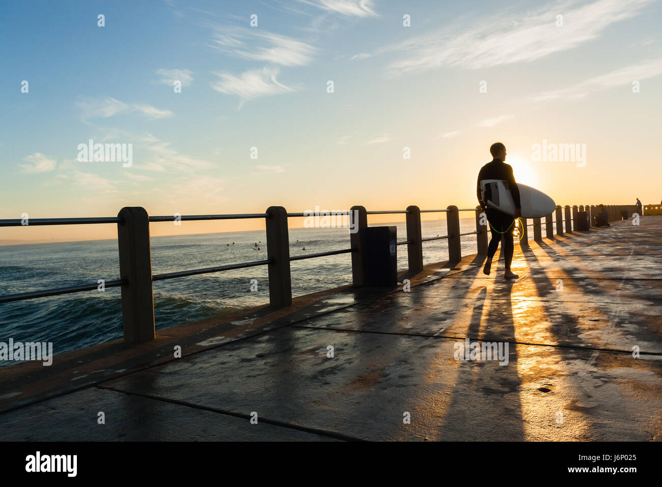 Surfen Surfer walking Silhouette Pier Beach Ocean Dawn Sonnenaufgang. Stockfoto