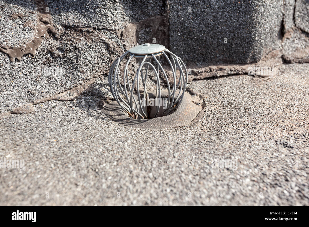 auf ein Flachdach ist Abfluss, um gegen Blätter halten Stockfoto