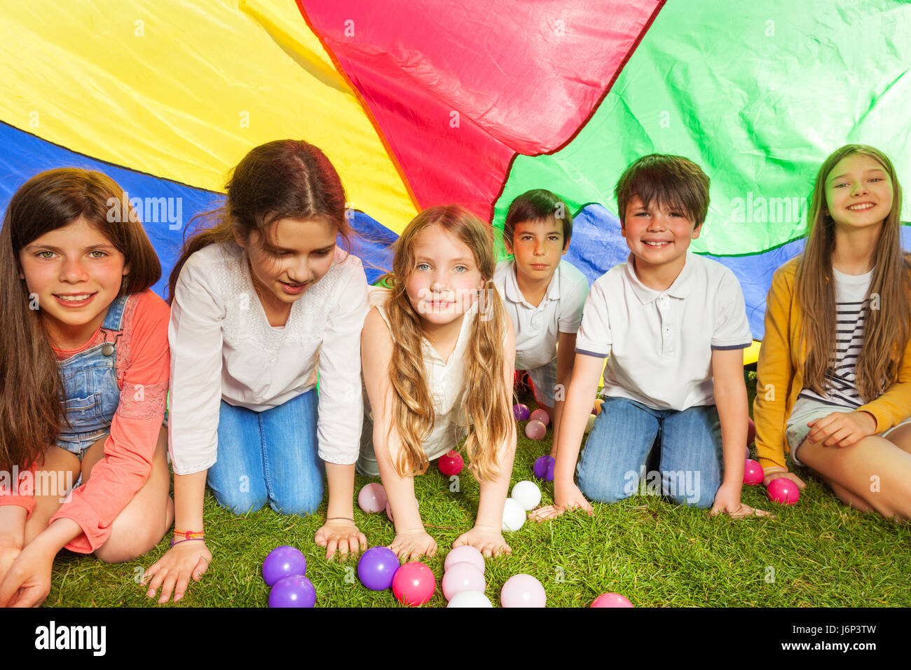 Porträt der glückliche Kinder versteckt unter Baldachin gemacht von bunten Fallschirm im Freien im Sommer Stockfoto