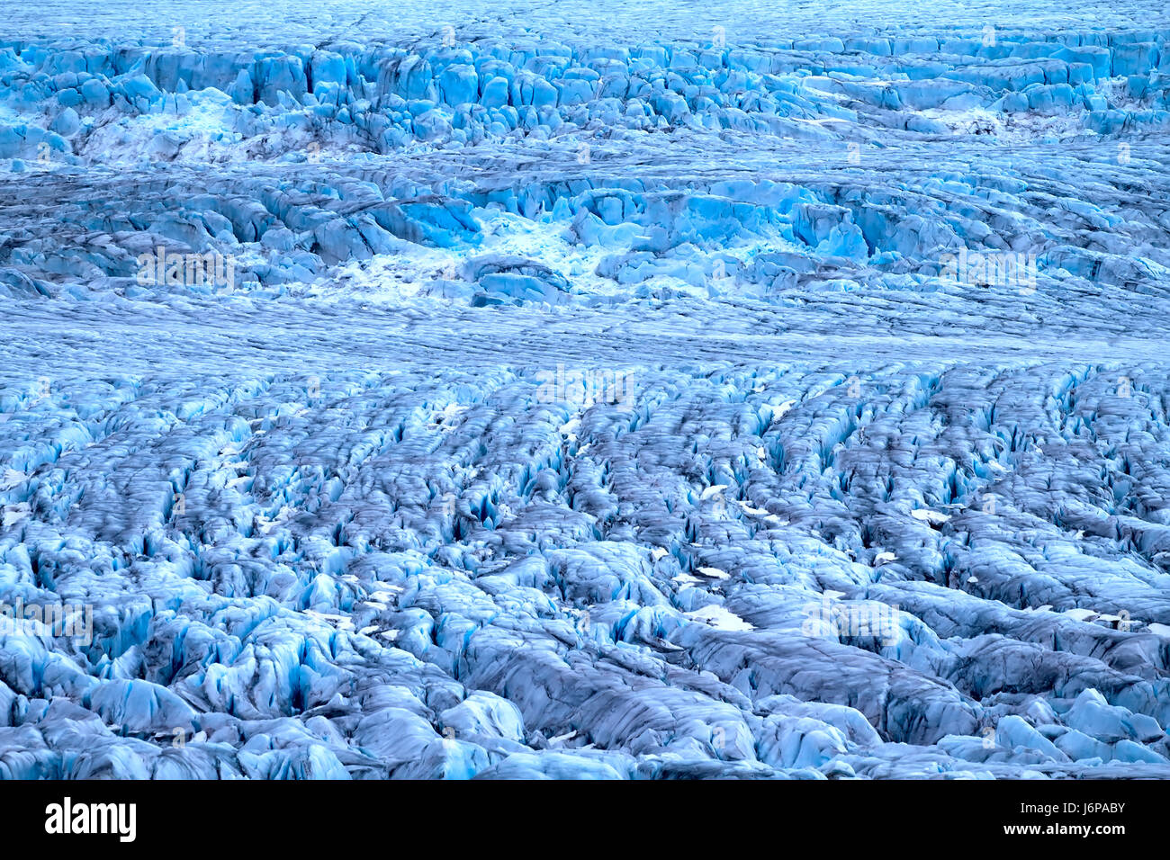 Raue Gletscher der Arktis. Live Gletscher. Eisfall auf hohen Felsen Bar. Nowaja Semlja-Archipel, Nordinsel. Blick vom Hubschrauber Stockfoto