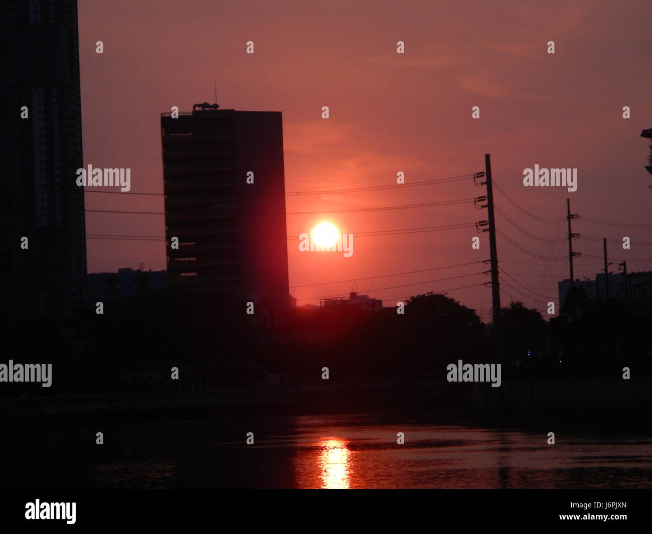Dieses Bild zeigt den wunderschönen Sonnenuntergang über Makati und Mandaluyong City, zwei wichtige Stadtgebiete in Metro Manila. Die lebhaften Farben unterstreichen die dynamische Skyline der Region in der Abenddämmerung. Stockfoto
