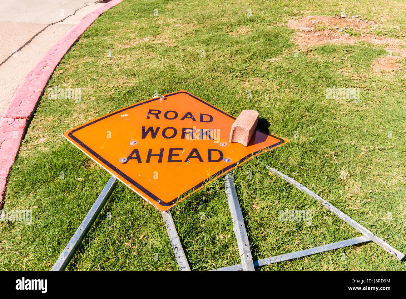 Ein nach unten Zeichen, Arbeit vor uns liegt, liegen in der Wiese neben einer Straße in Oklahoma City, Oklahoma, USA. Stockfoto