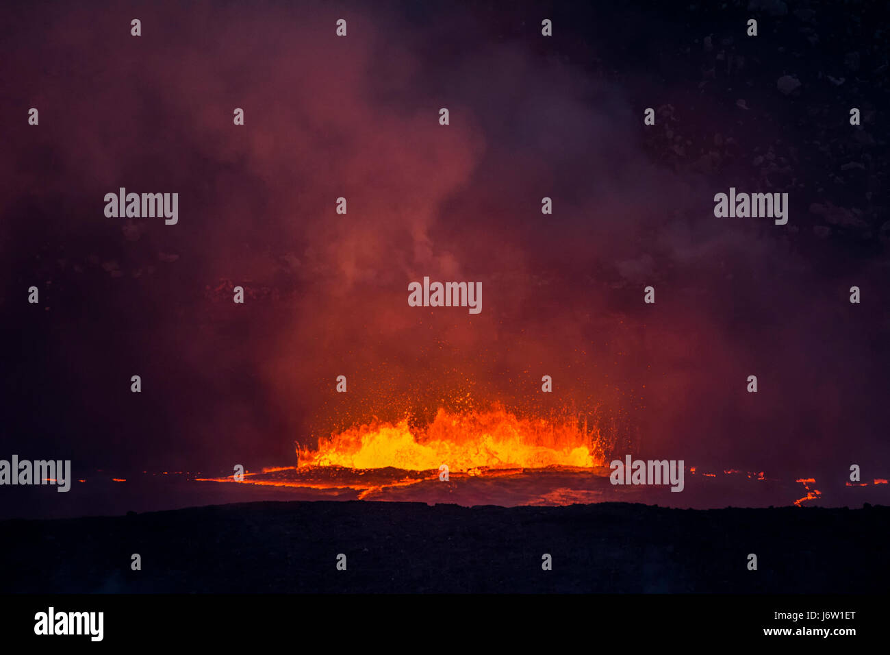 Kochendes, ausbrechender Lava in die Caldera des Vulkans Kilauea schießt Magma in die Luft und erzeugt große Mengen an Dampf aus der heißen Flüssigkeit. Stockfoto