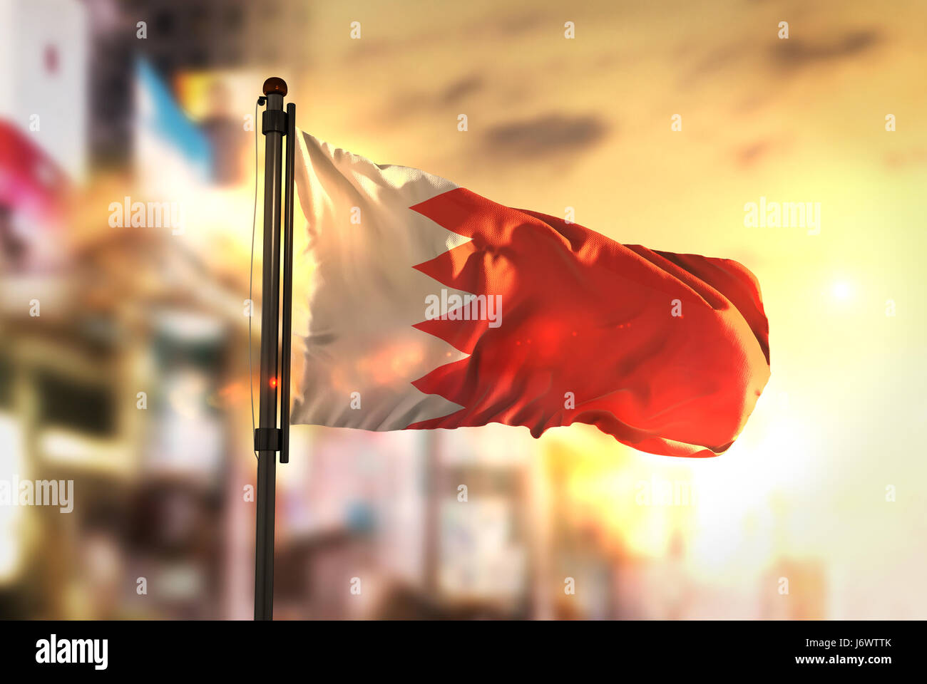 Bahrain Flagge gegen City unscharf Hintergrund bei Sonnenaufgang Hintergrundbeleuchtung Stockfoto