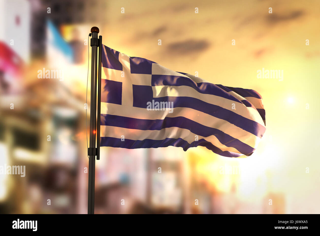 Griechenland Flagge gegen City unscharf Hintergrund bei Sonnenaufgang Hintergrundbeleuchtung Stockfoto