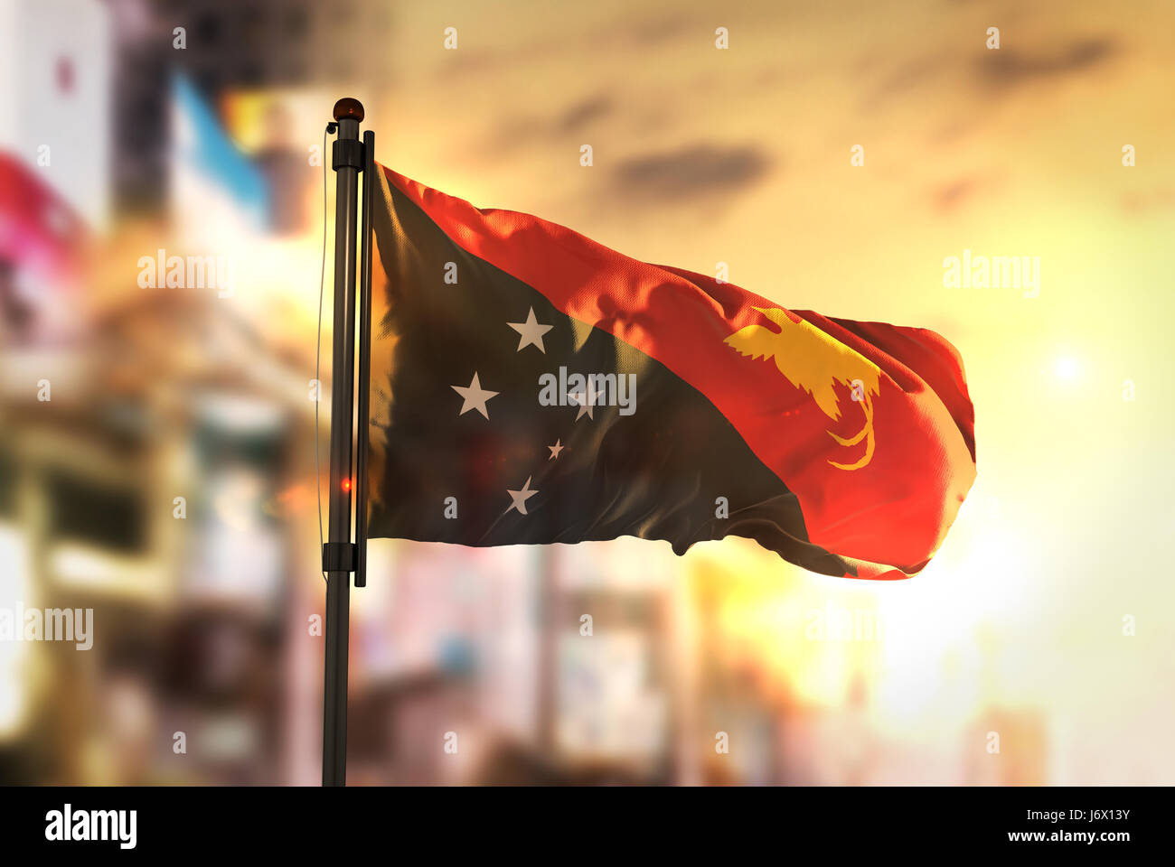 Papua-Neu-Guinea Fahne gegen City unscharf Hintergrund bei Sonnenaufgang Hintergrundbeleuchtung Stockfoto