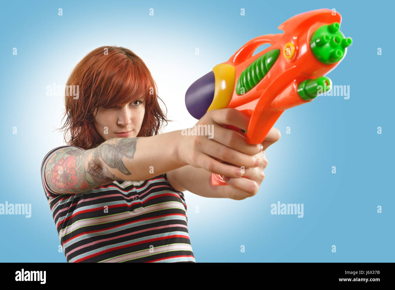 weibliche Spritzen Schießen Pistole Waffe Begeisterung Unterhaltung Freude Freude Gag Witz Stockfoto