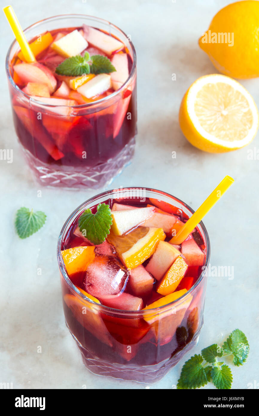 Rot Wein Sangria oder Bowle mit Früchten, Minze und Eis in Gläser. Homemade erfrischende Frucht Sangria über rustikale weißen Tisch, Textfreiraum Stockfoto