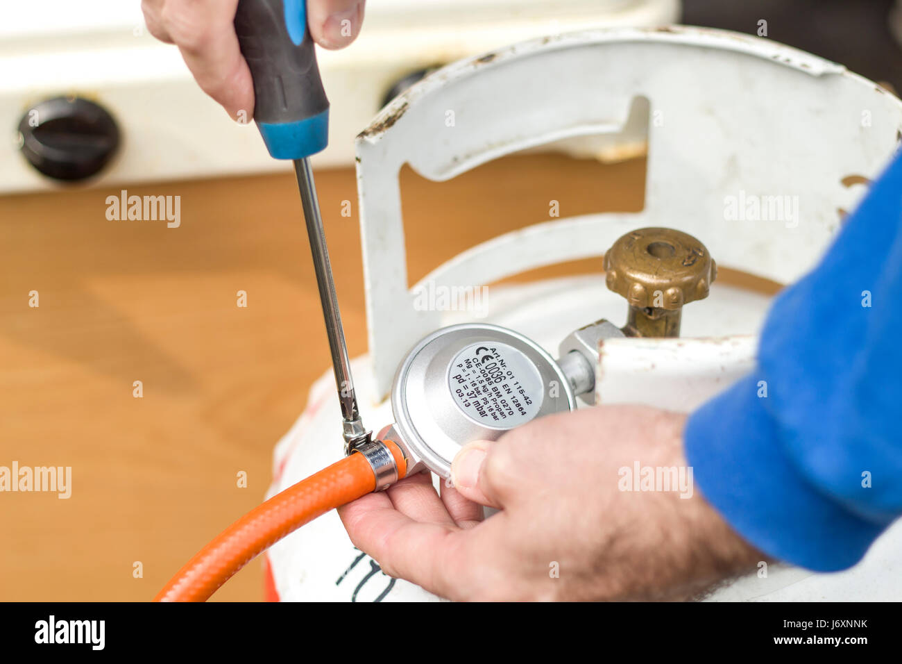 Verschrauben Sie das Spannband mit dem Gummischlauch aus dem Gas-Zylinder-Reduzierstück Stockfoto