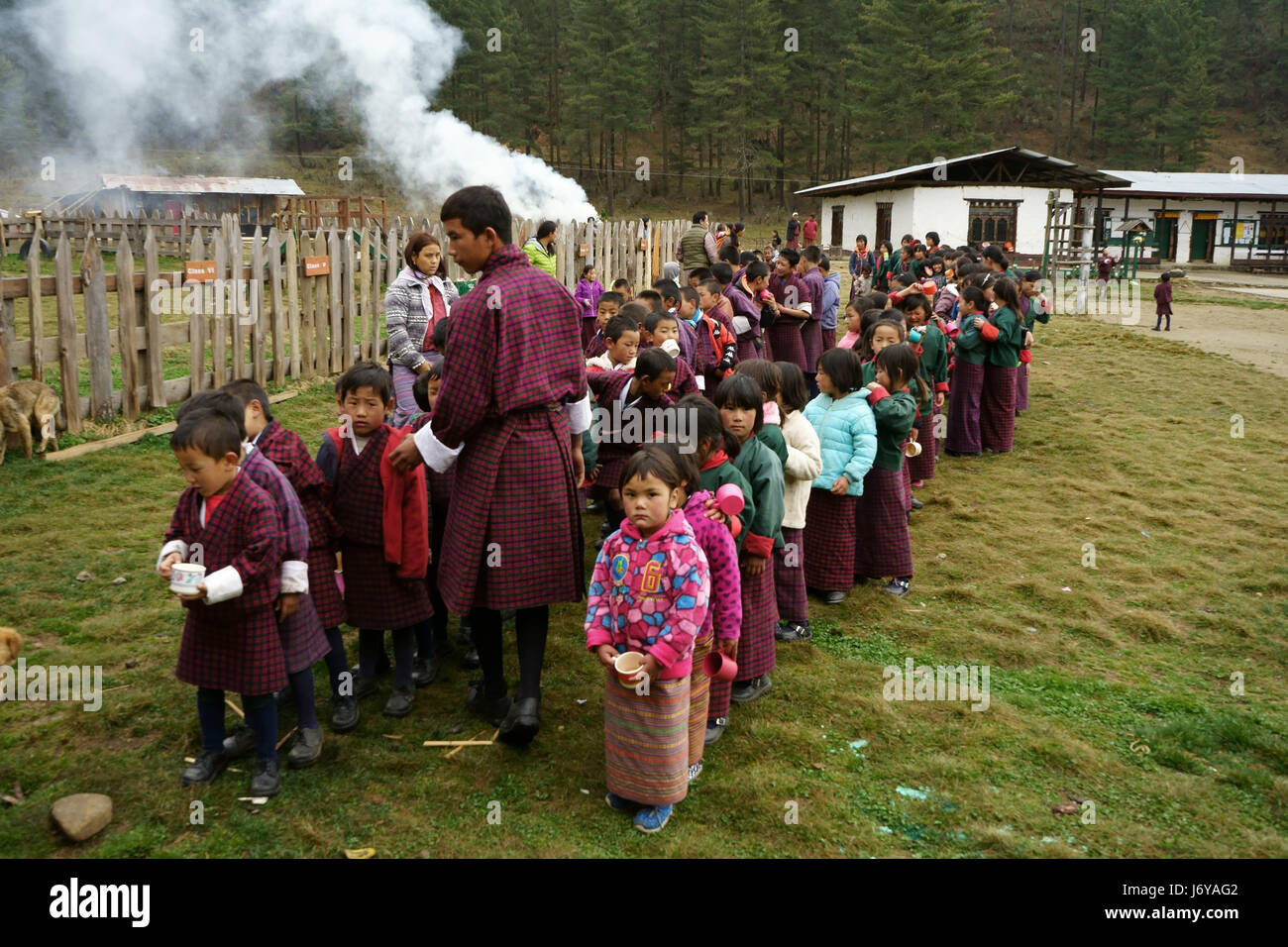 Schülerinnen und Schüler Line-up für das Mittagessen in der Grundschule Phobjika, Bhutan Stockfoto