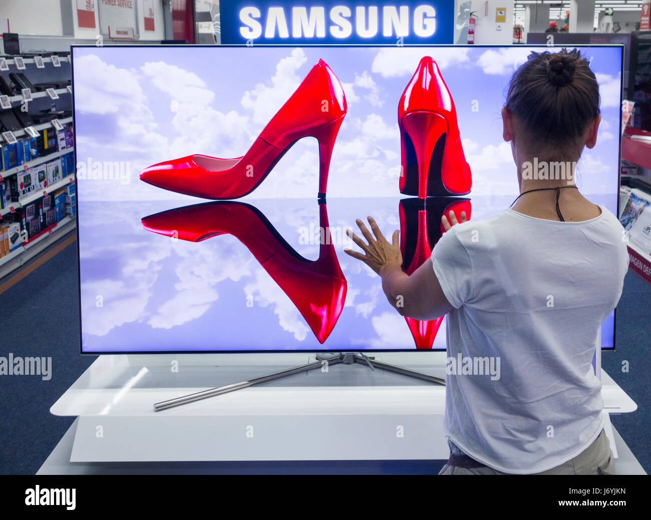 Frau-TV Samsung QLED in elektrische Speicher betrachten. Stockfoto