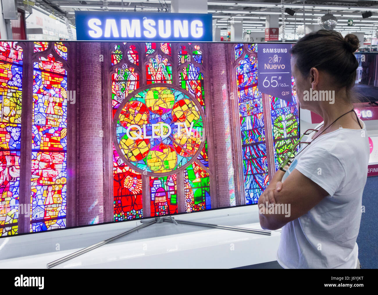 Frau-TV Samsung QLED in elektrische Speicher betrachten. Stockfoto