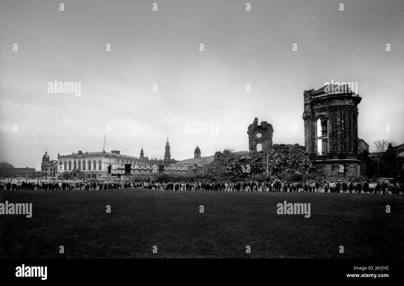Dresden in dem, was war dann DDR November 1989 die Straßen von Dresden, Sachsen, in der ehemaligen DDR in der Woche nach dem Fall der Mauer in Berlin, November 1989 fotografiert. Die Ruine der Frauenkirche zerstört in der RAF und der USAAF Bombenangriffe im Jahr 1945. Hunderte von ostdeutschen Warteschlange, Osten Marks, Ost-Mark, in West-Deutsche Mark bei eins zu eins tauschen. Wikipeadia: Dresden hat eine lange Geschichte als Hauptstadt und königliche Residenz für den Kurfürsten und Könige von Sachsen, die seit Jahrhunderten die Stadt mit kulturellen und künstlerischen Pracht ausgestattet. Die Stadt wurde bekannt als das Schmuckkästchen, Stockfoto