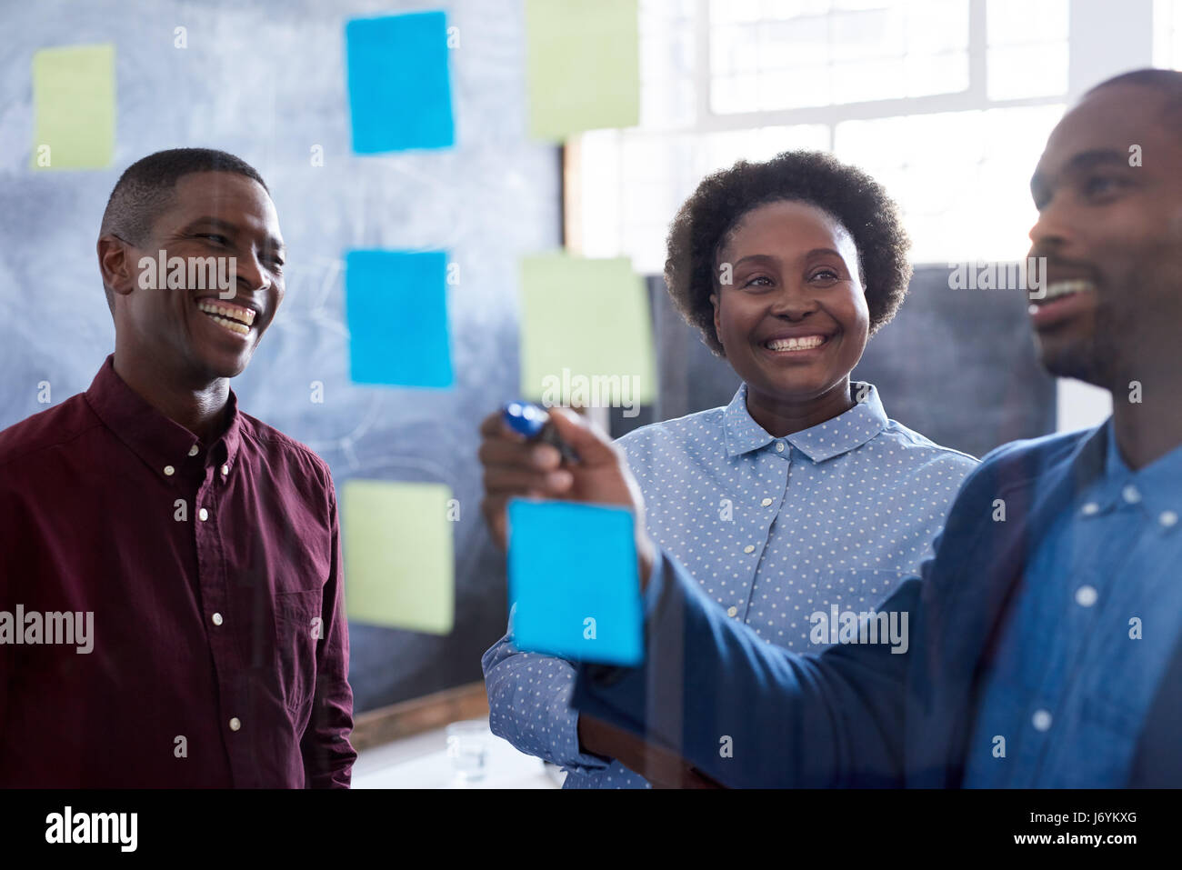 Lächelnde afrikanische Arbeitskollegen brainstorming im Büro Stockfoto