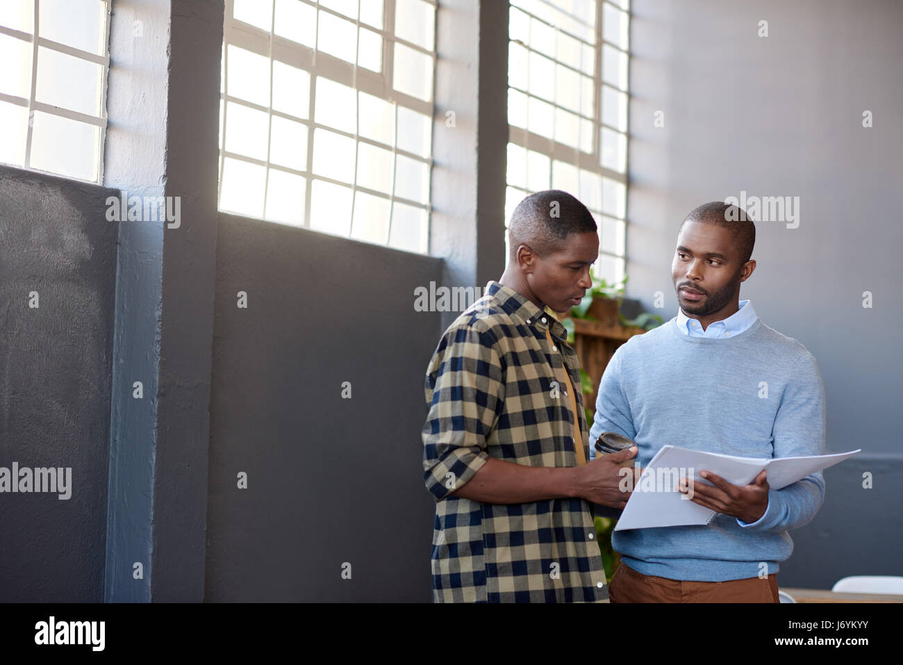 Konzentrierte sich afrikanische Unternehmer diskutieren Papierkram zusammen in einem Büro Stockfoto