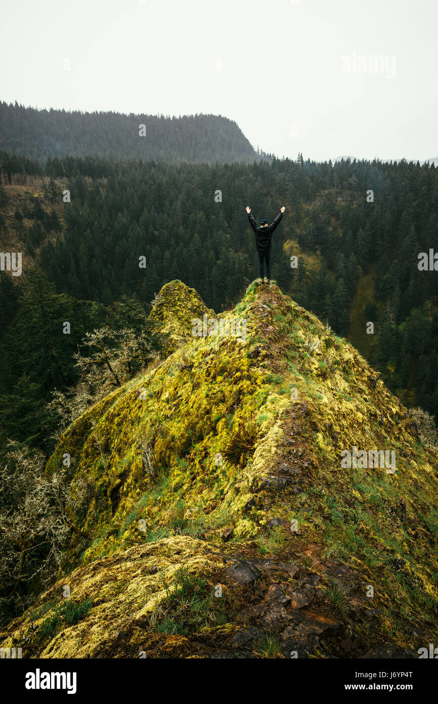 Mann, der auf dem Gipfel des Berges mit erhobenem Arm steht, Columbia River Gorge, Washington, USA Stockfoto