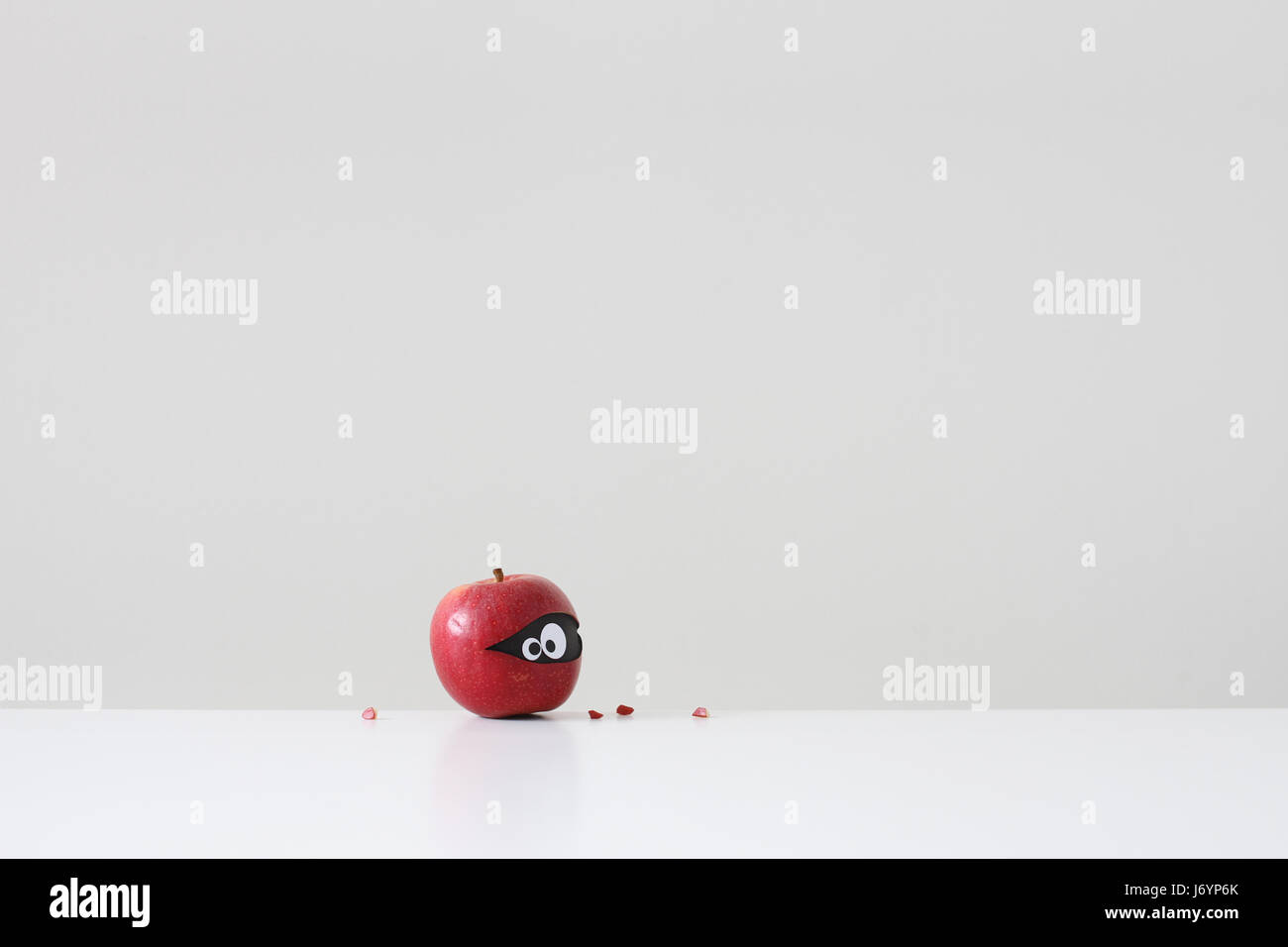 Roter Apfel mit Augen versteckt im Inneren Stockfoto