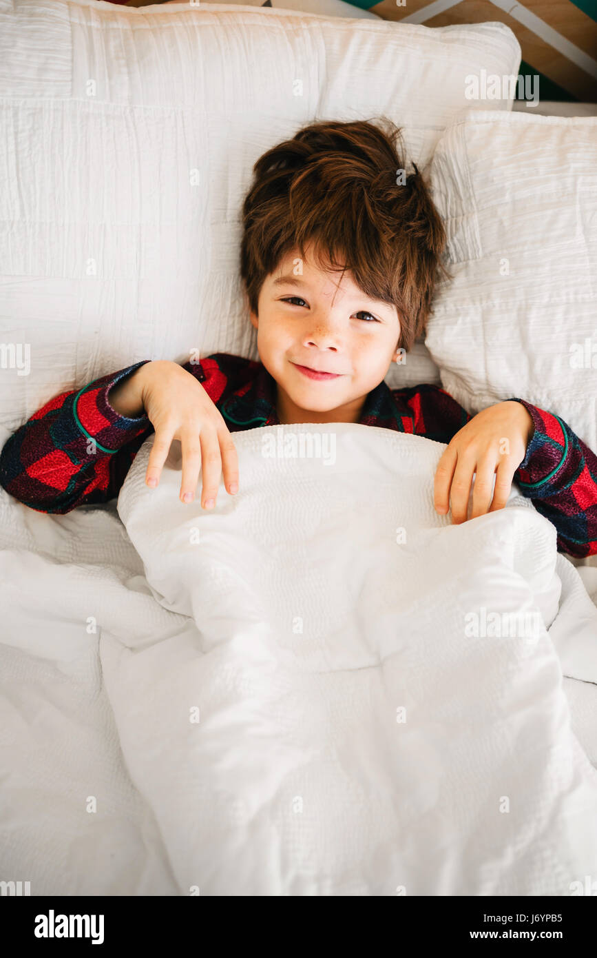 Portrait eines lächelnden jungen im Bett liegend Stockfoto