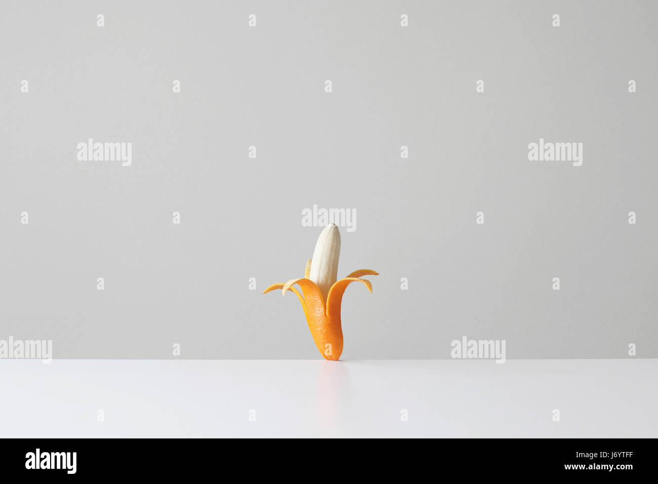 Konzeptionelle Banane in einer Orangenhaut Stockfoto
