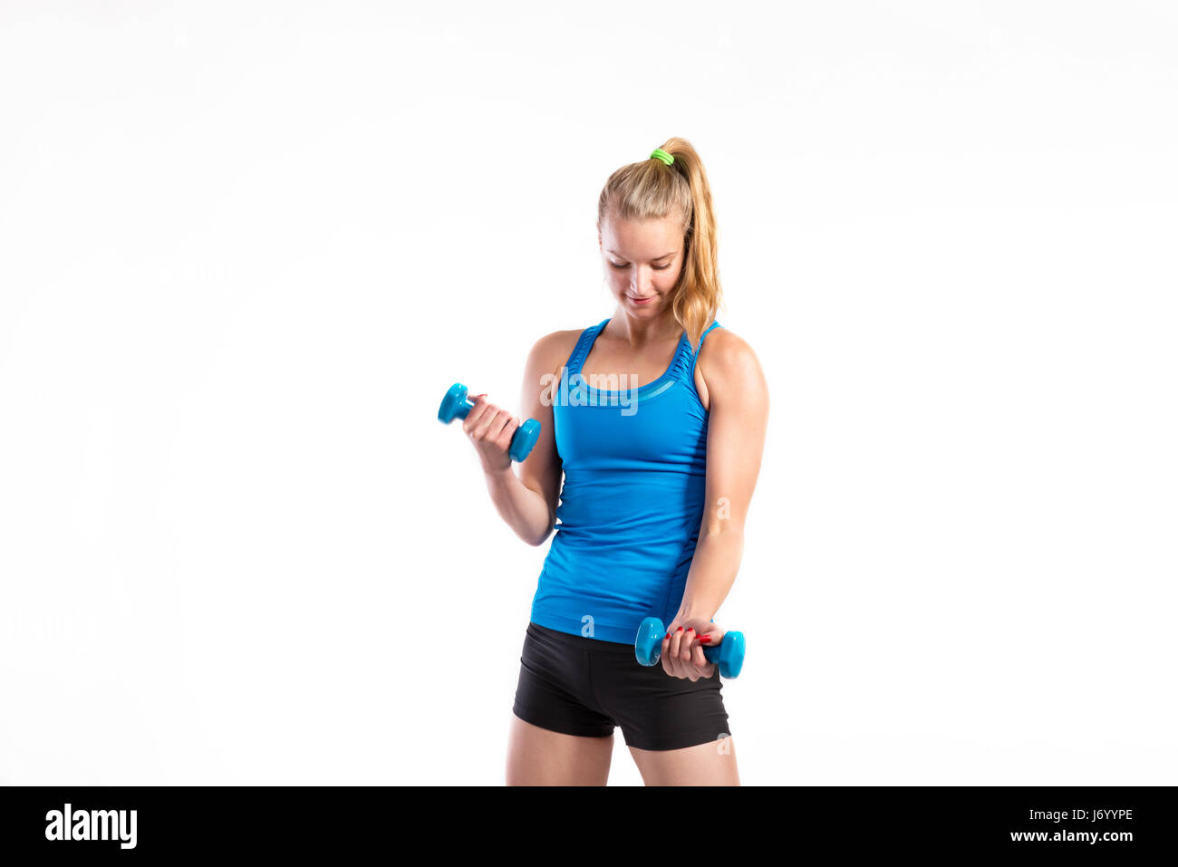 Attraktive junge Fitness Frau mit Hanteln. Studio gedreht. Stockfoto