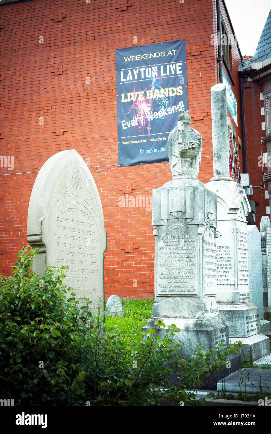 Plakat Werbung für live-Bands an Wand mit Blick auf Gräbern im Friedhof Stockfoto