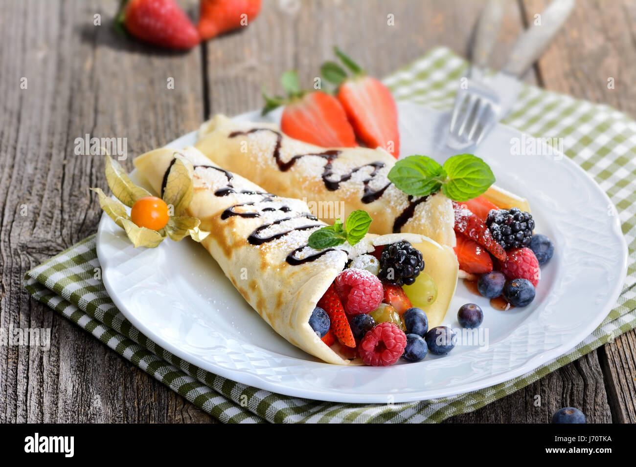 Zwei hausgemachte Pfannkuchen gefüllt mit frischen Waldbeeren Stockfoto