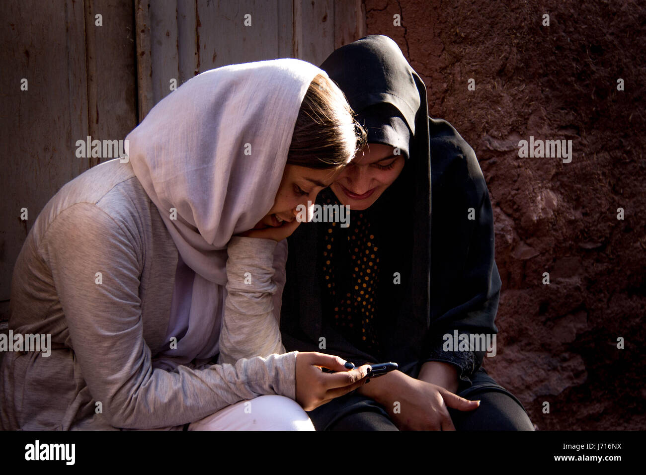 Mädchen spielen mit Smartphone, Abyāneh, Iran Stockfoto