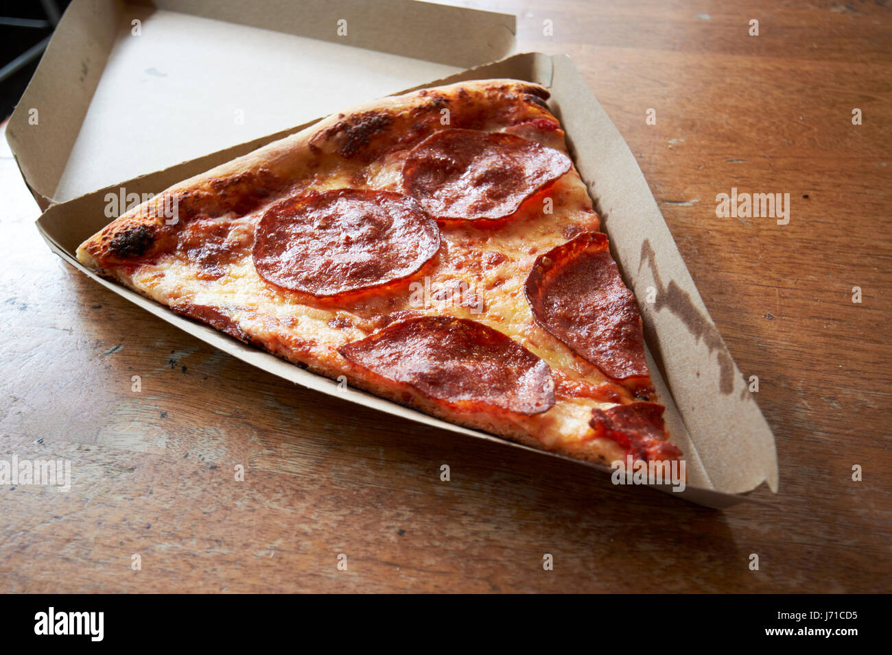 großes Stück Peperoni Pizza in einem einzigen Stück Karton USA Stockfoto