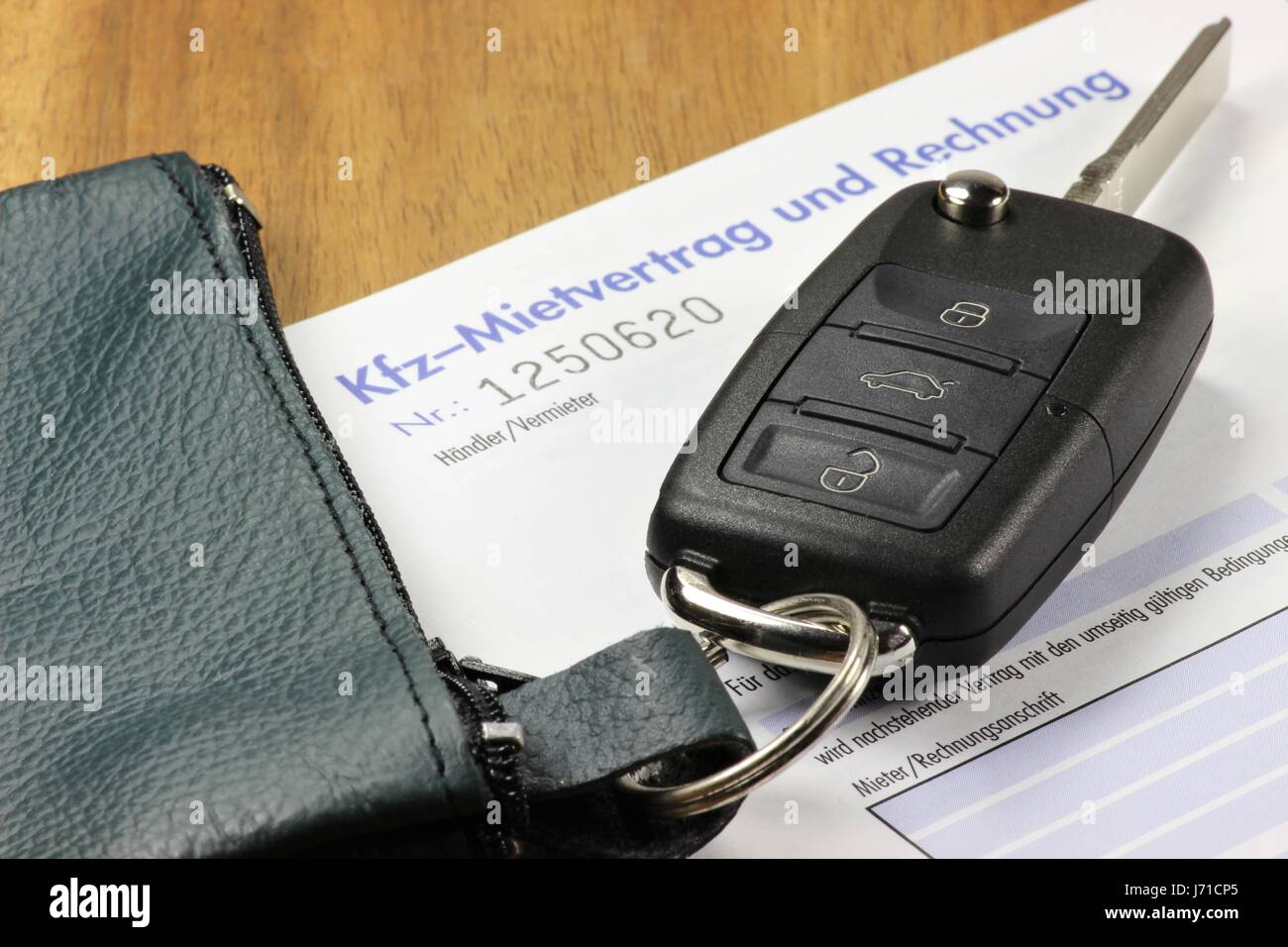Autoschlüssel und deutsches Auto Mietvertrag auf desktop Stockfoto