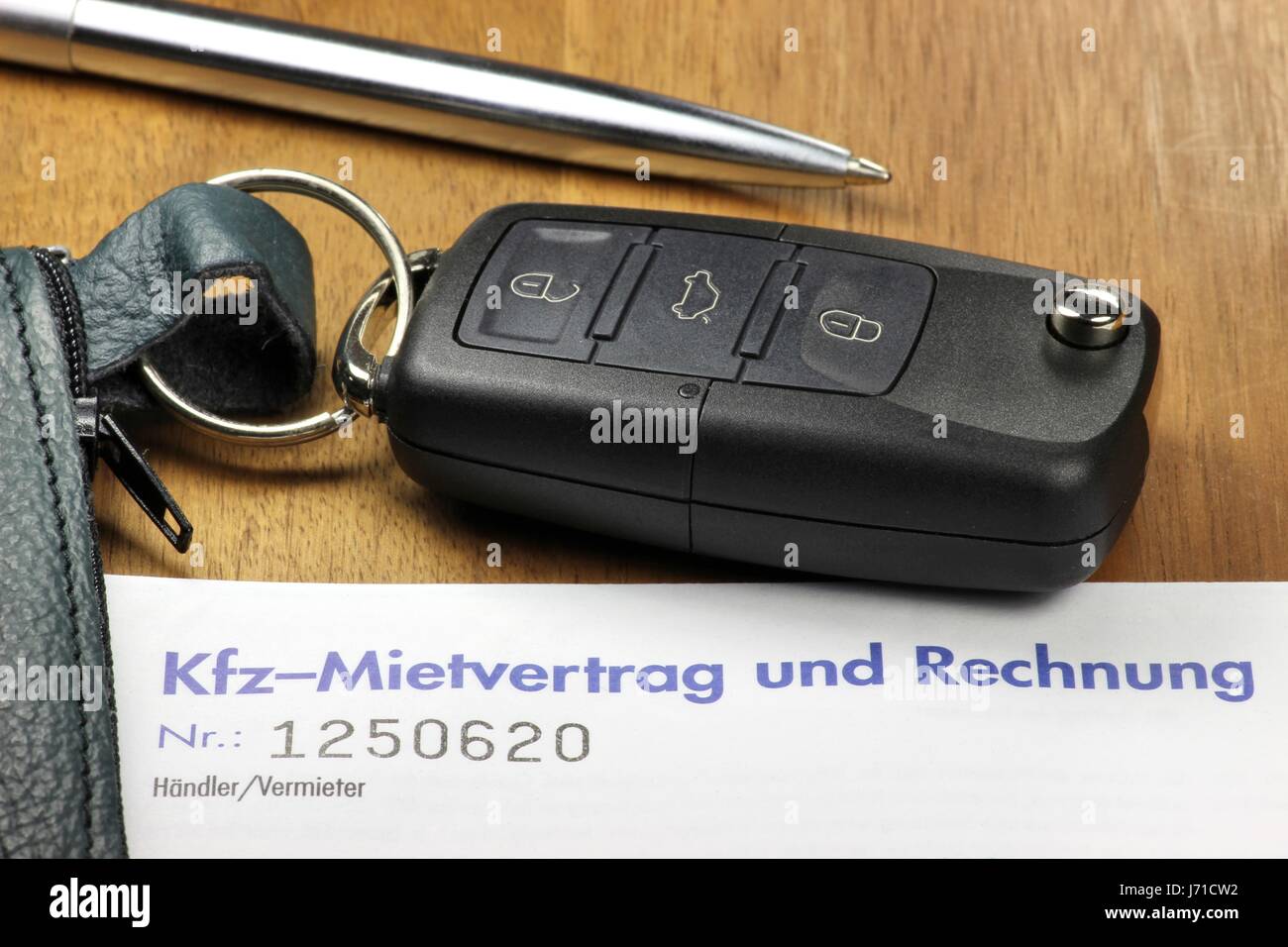 Autoschlüssel und deutsches Auto Mietvertrag auf desktop Stockfoto
