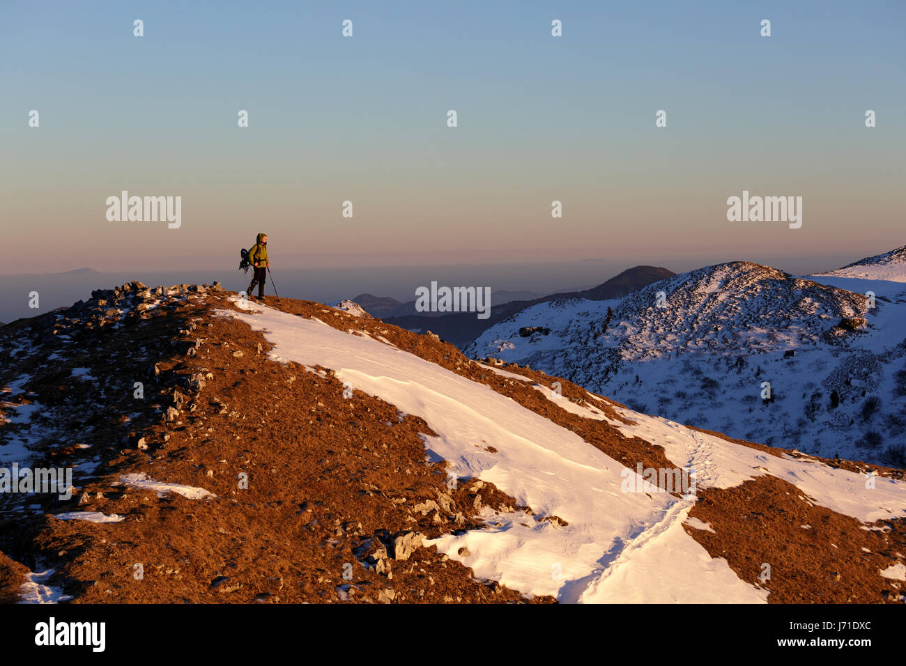 Frau am Gipfel des Berges bei Sonnenuntergang, Mozic, Slatnik, Slowenien wandern. Stockfoto