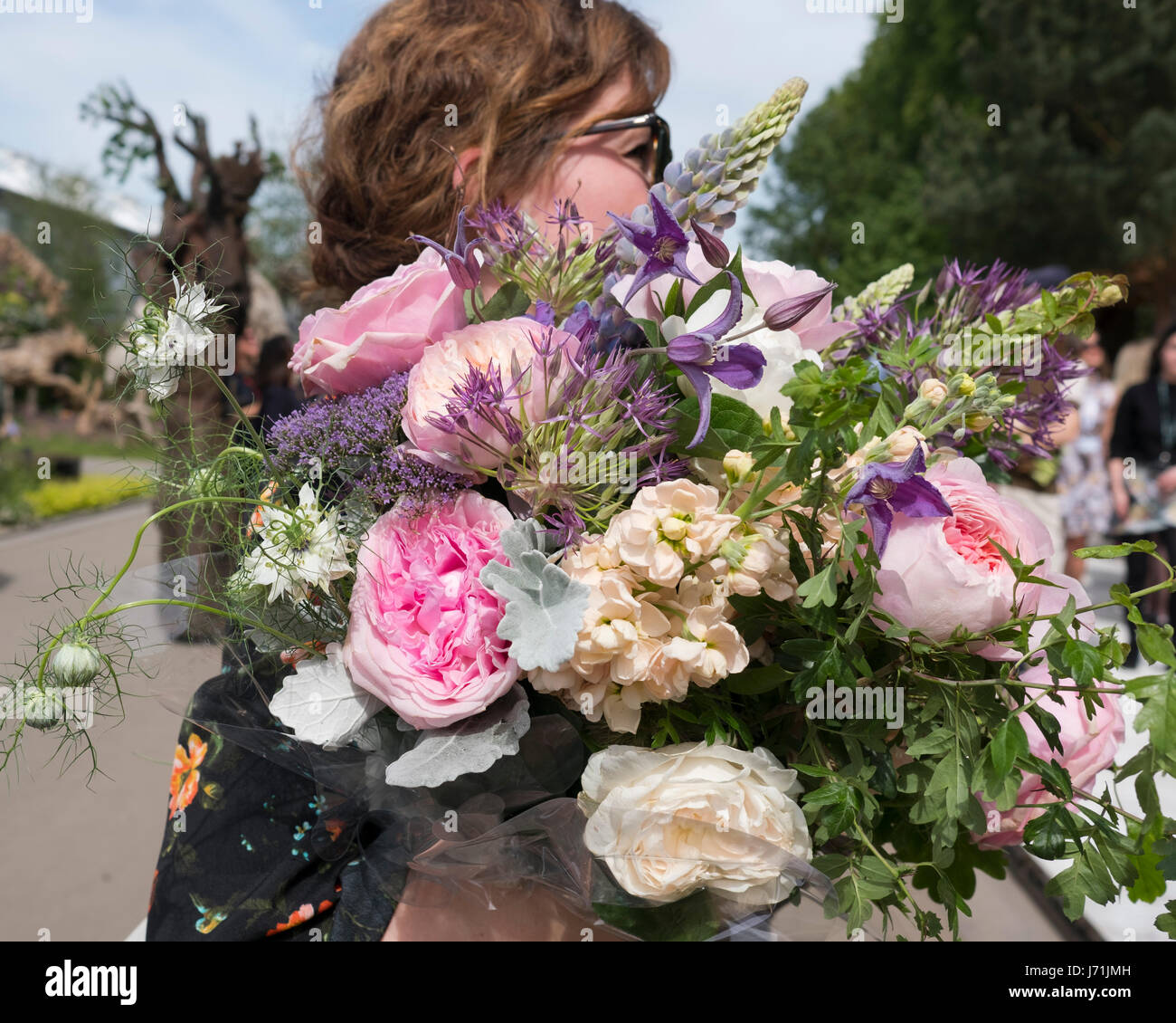 London, UK. 22. Mai 2017. Eine Frau, die einen großen Strauß Rosen und Pfingstrosen bei der RHS Chelsea Flower Show 2017, London, UK Credit: Ellen Rooney/Alamy Live News Stockfoto