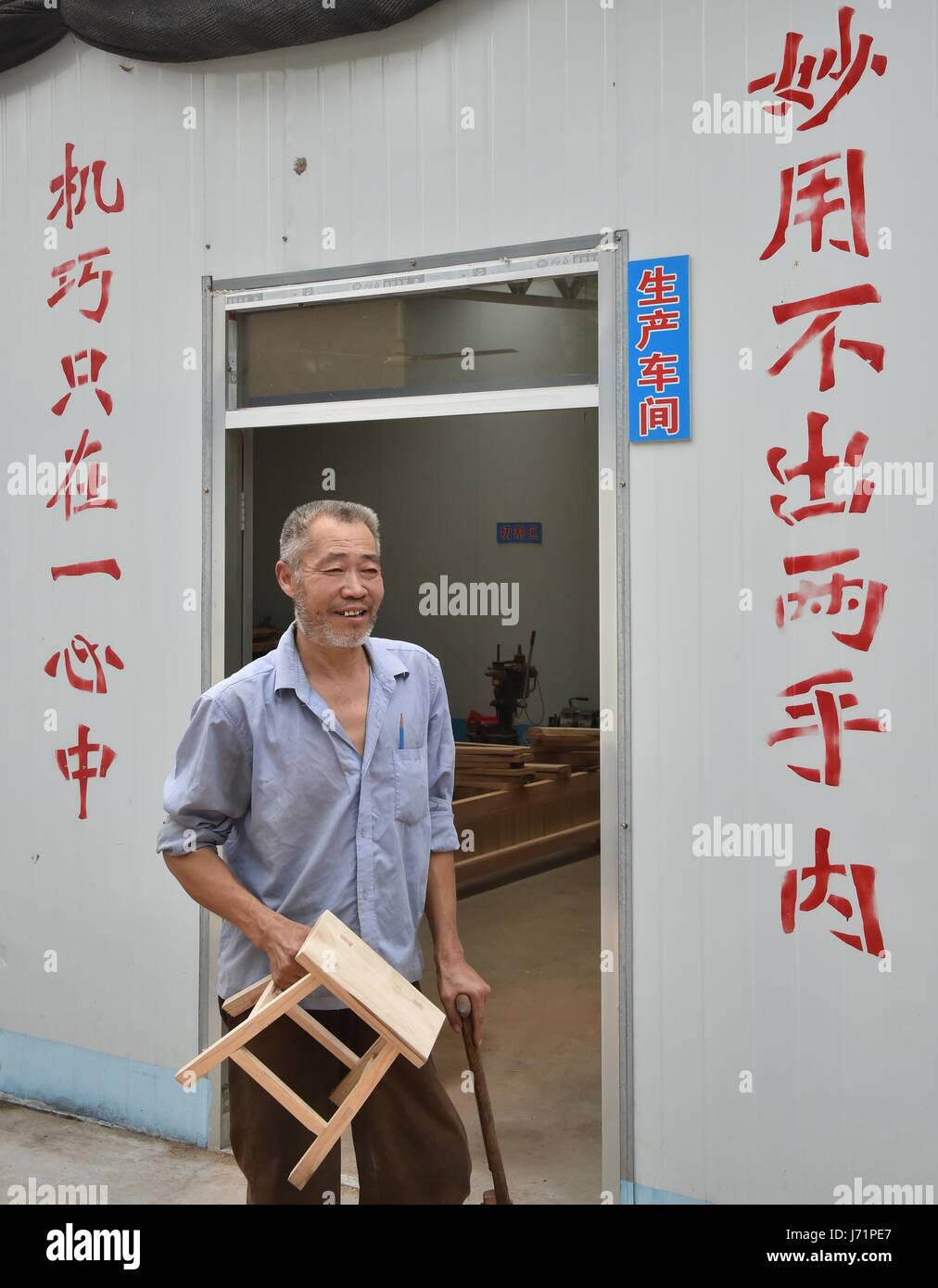 (170523)--JINAN, 23. Mai 2017 (Xinhua)--Zhao Shuhuan hält eine Holzbank Probe in seiner Werkstatt in der Dongtai Dorf der Zhutai Township in Zibo, Ost-China Shandong Provinz, 22. Mai 2017. 54-j hrige Zhao hat Bein Behinderung seit seiner Kindheit hatte. Als er Elder und die Reduzierung der Nachfrage für Zimmerei wuchs, brachte sich Zhao Armut. Vor zwei Jahren half lokale Armutslinderung Abteilung Zhao, eine Werkstatt zu bauen und zu schneiden und polierende Maschinen als eine gezielte Maßnahme in Armutslinderung Kampagnen kaufen. Es fand auch einen Stand auf einem Möbelmarkt für ihn. Umsatzvolumen von Stockfoto