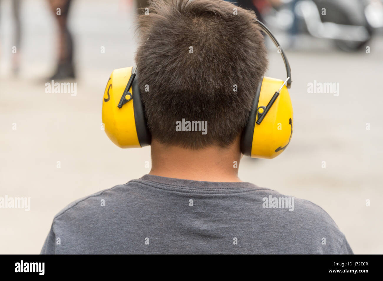 Kleiner Junge schützende Kopfhörer tragen, um sich vor Lärm zu schützen Stockfoto