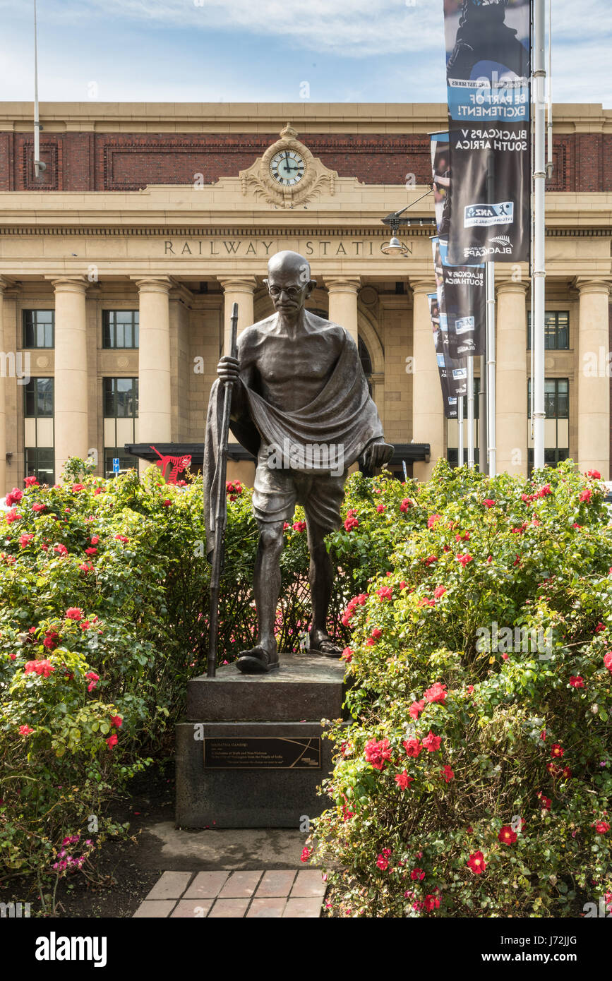 Wellington, New Zealand - 10. März 2017: Classic iconic Mahatma Gandhi Bronze Statue vor gelben Hauptbahnhof mit Uhr. Grüner bus Stockfoto