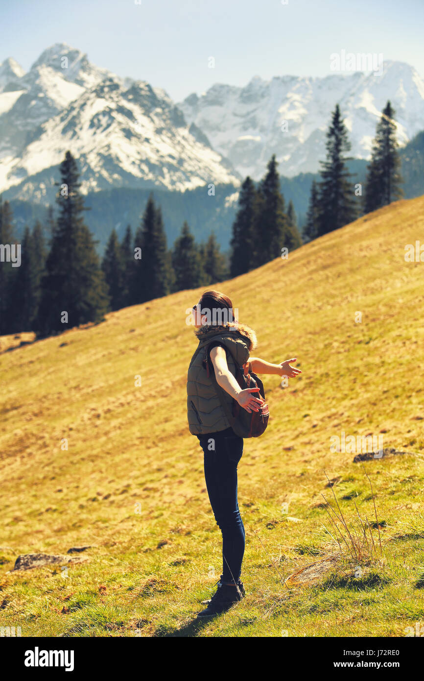 Hübsche Frau gefangen Frischluft auf Berghügel. Ein weißer Tourist Mädchen Wandern in den Alpen. Sommer Gebirgshintergrund. Stockfoto