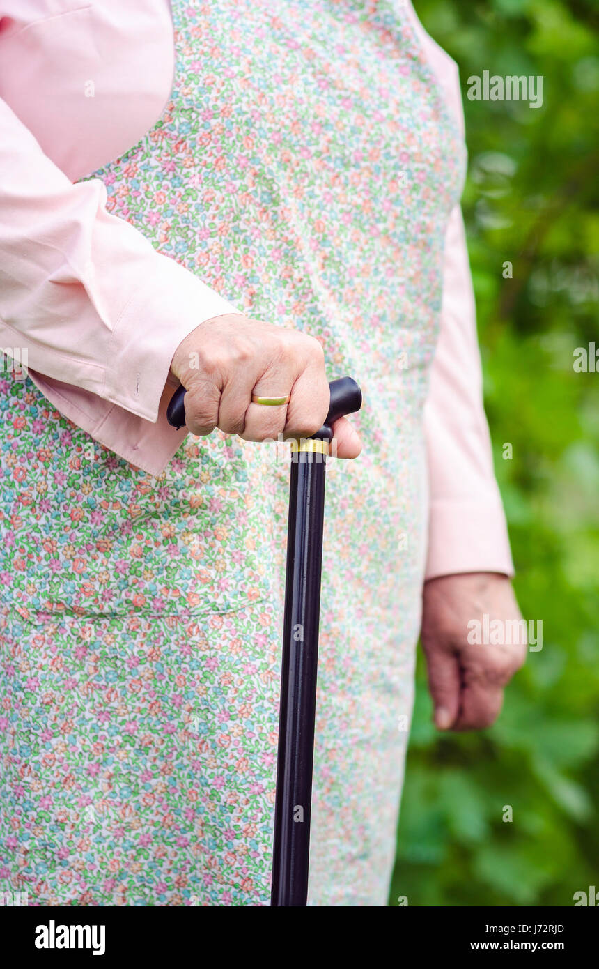 Alten übergewichtige Frau zu Fuß mit Stick vertikal Stockfoto