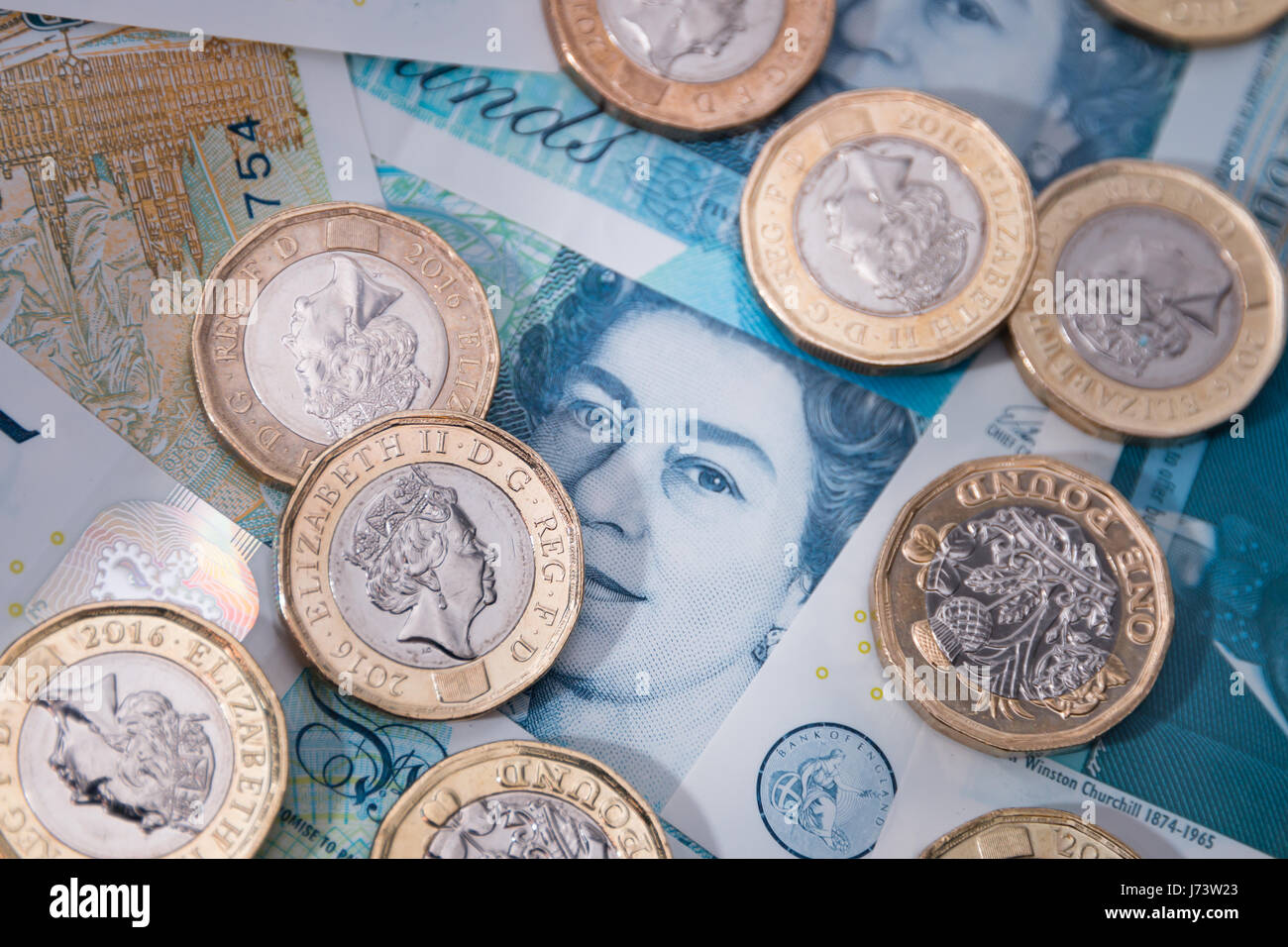 Neue Pfund-Münzen oben auf neue Kunststoff fünf-Pfund-Noten Stockfoto