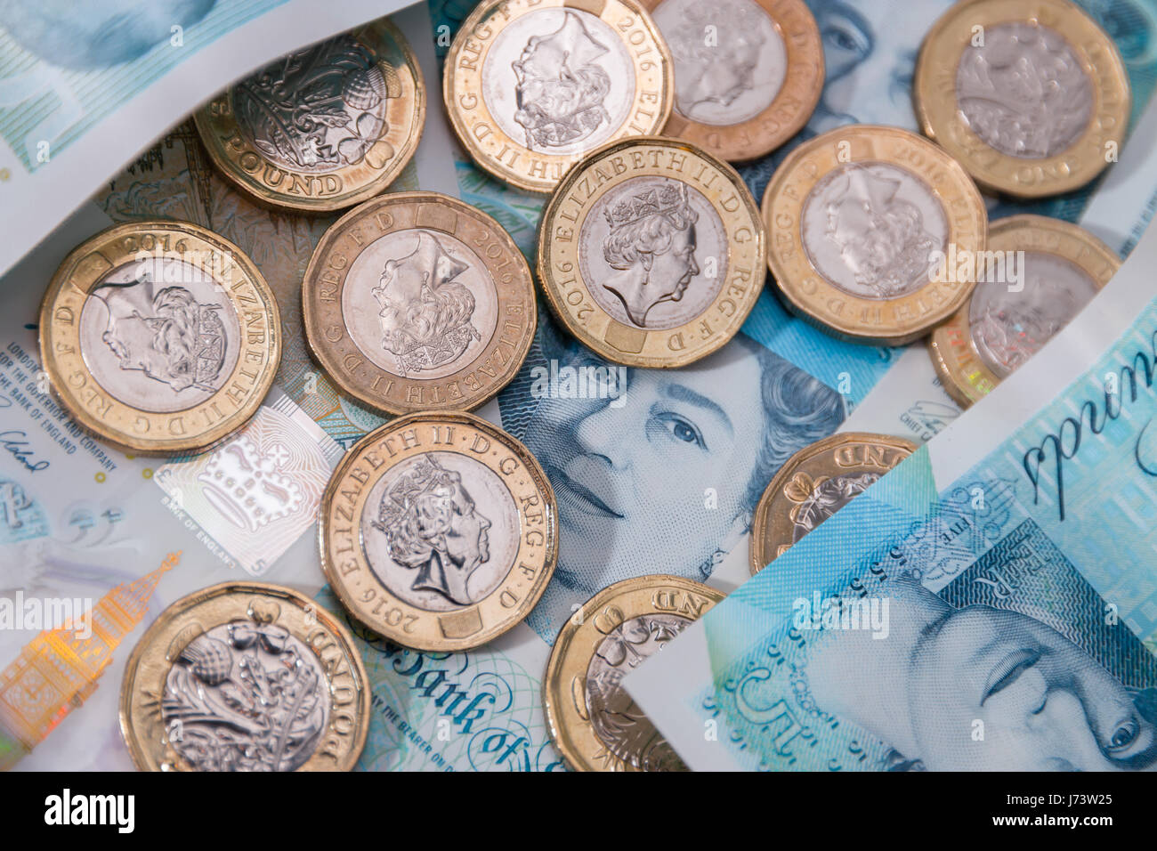 Neue Pfund-Münzen oben auf neue Kunststoff fünf-Pfund-Noten Stockfoto