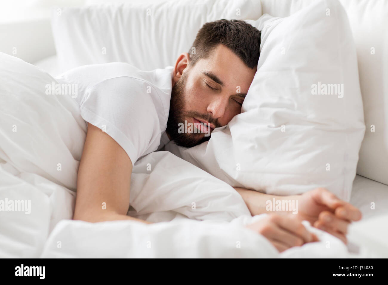 Nahaufnahme von Mann schlafend im Bett zu Hause Stockfoto