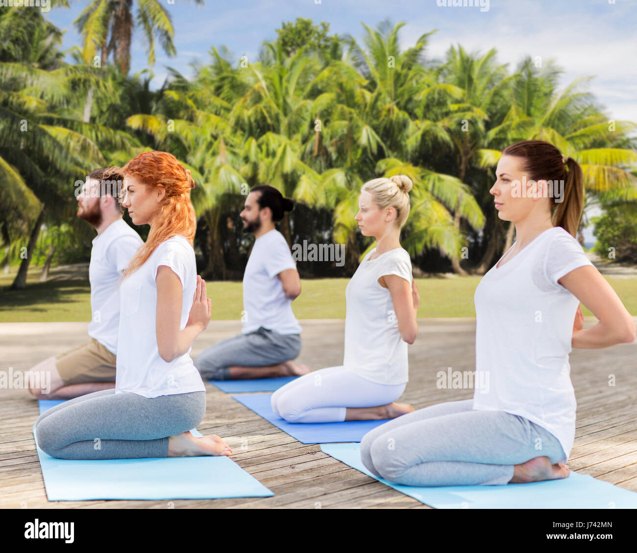 Menschen, die Yoga in Held-Pose im freien Stockfoto