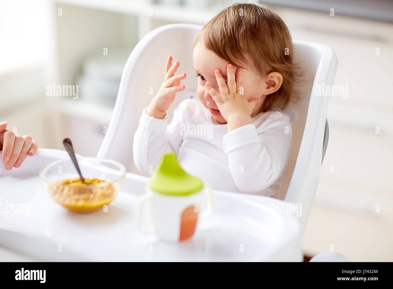 Baby im Hochstuhl sitzen und Essen zu Hause Stockfoto