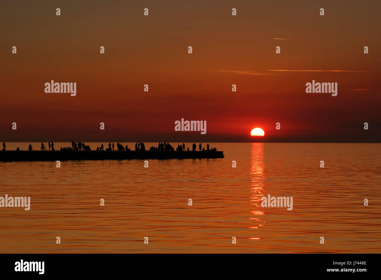 Genießen den Sonnenuntergang und die schöne Atmosphäre auf dem berühmten Pier Molo Audace in Triest (Italien). Stockfoto