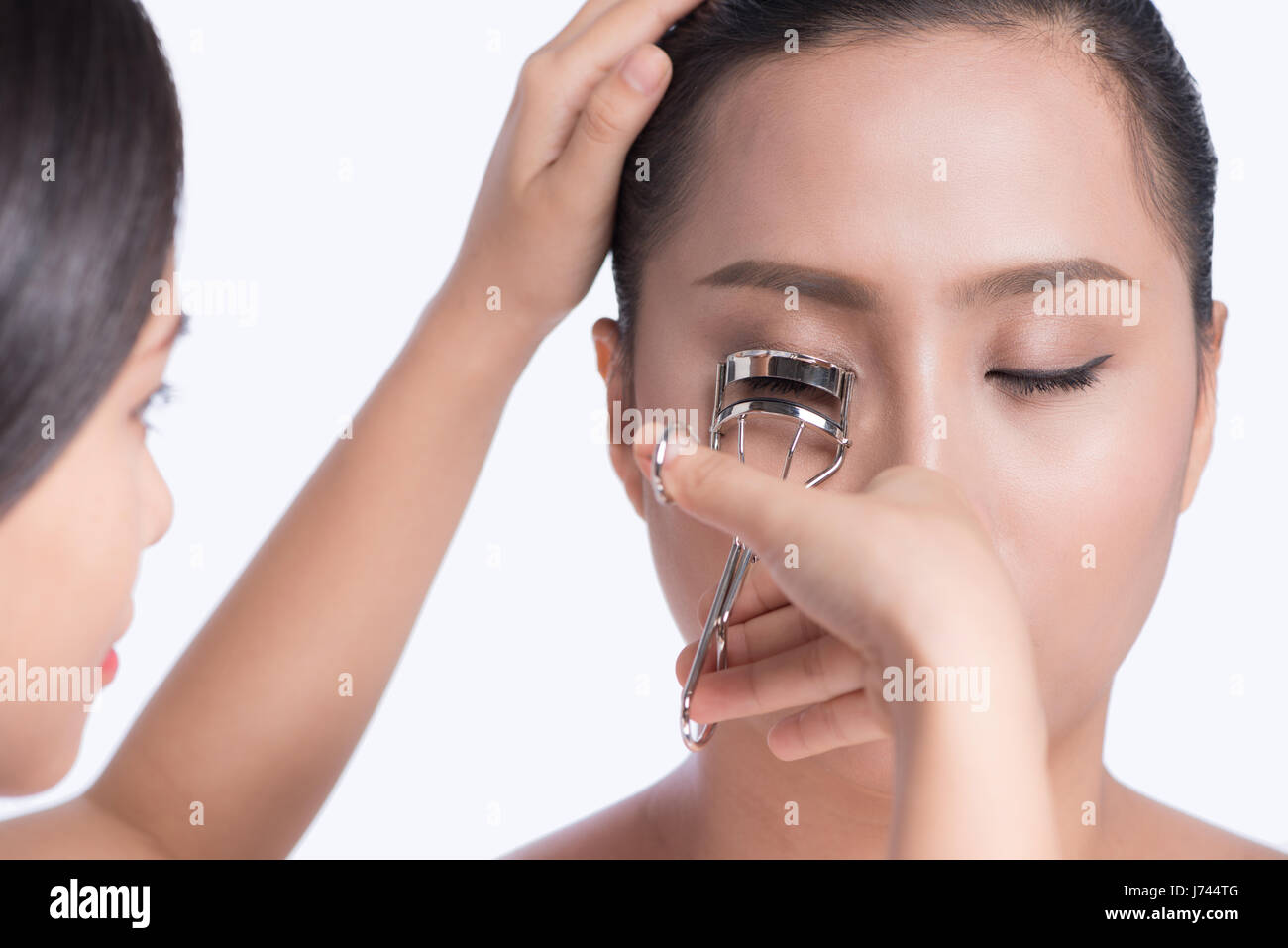 Make-up-Artist curling Wimpern für asiatische Model. Stockfoto