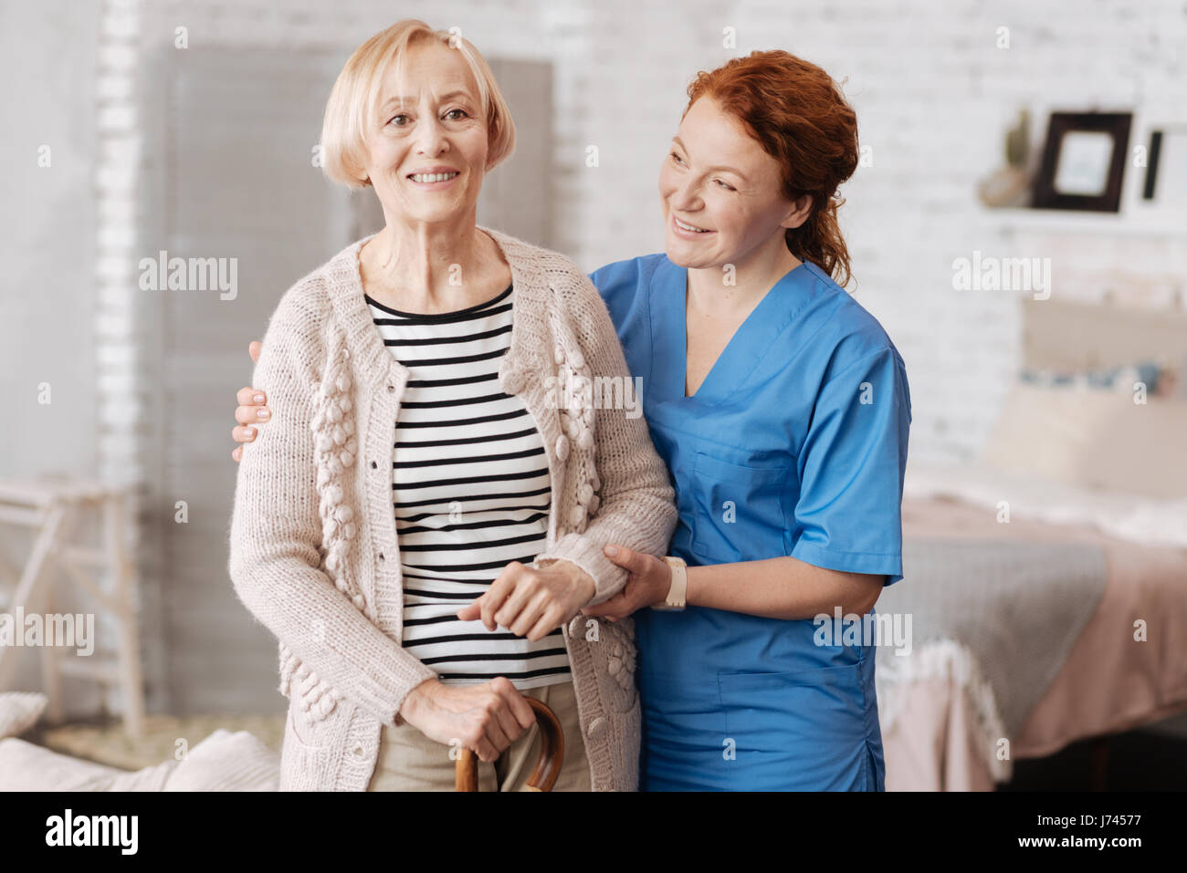 Hervorragende private Krankenschwester helfen Reife Dame stehend Stockfoto