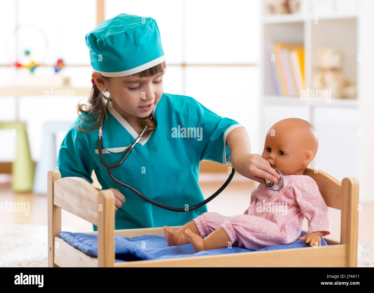 Kind Mädchen mit Puppe im Krankenhaus spielt Stockfoto