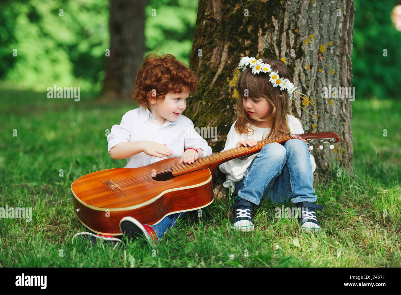 niedliche kleine Kinder, die Gitarre zu spielen Stockfotografie - Alamy