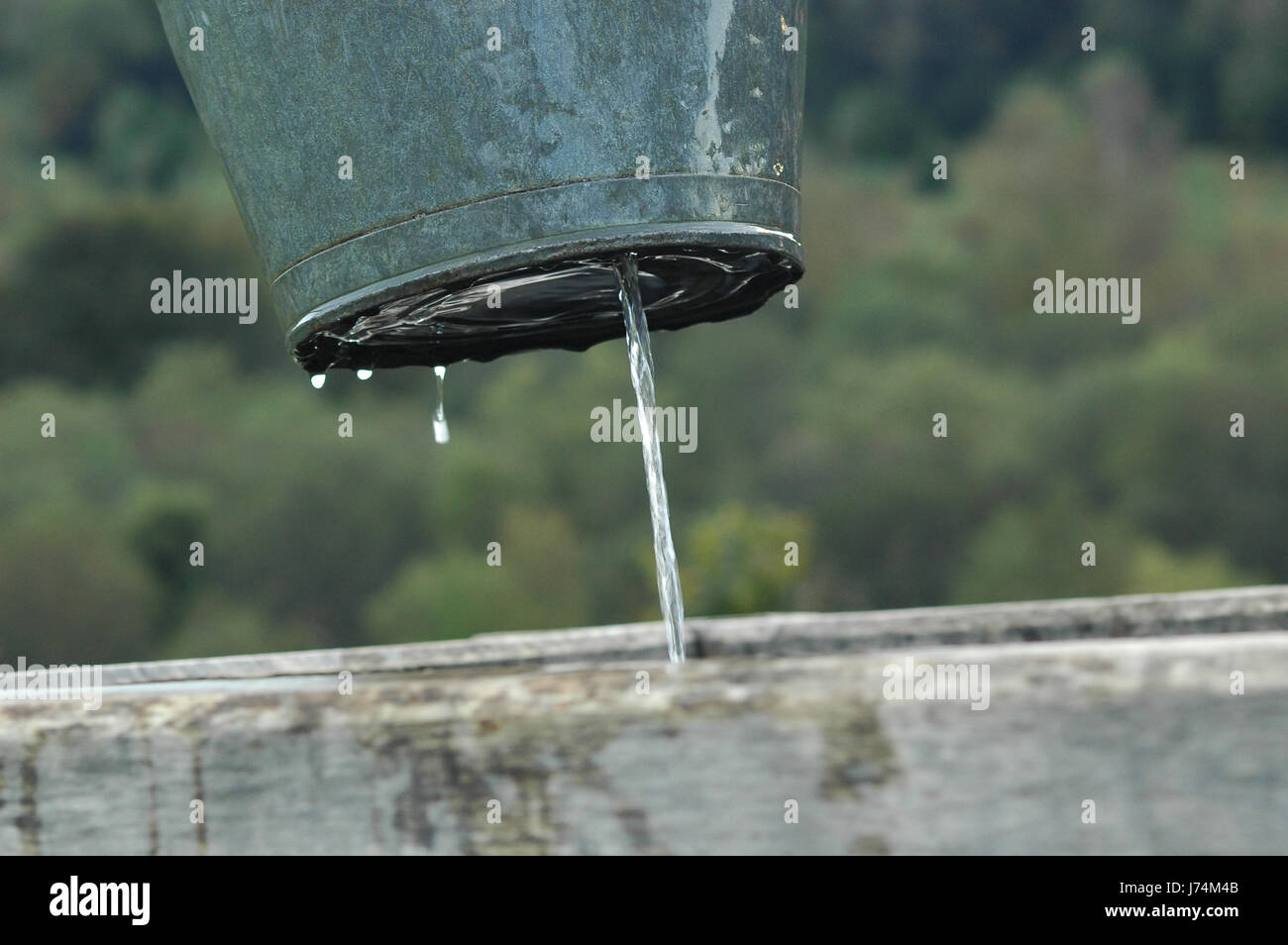 Eimer, Wasser, Verlust, Brunnen, Loch, Leck, Wasser, Flüssigkeit,  Flüssigkeit, Blecheimer jet Stockfotografie - Alamy