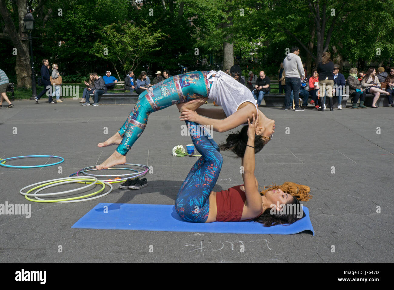 Zwei hübsche junge Damen tun Acroyoga im Washington Square Park in Greenwich Village, New York City. Stockfoto